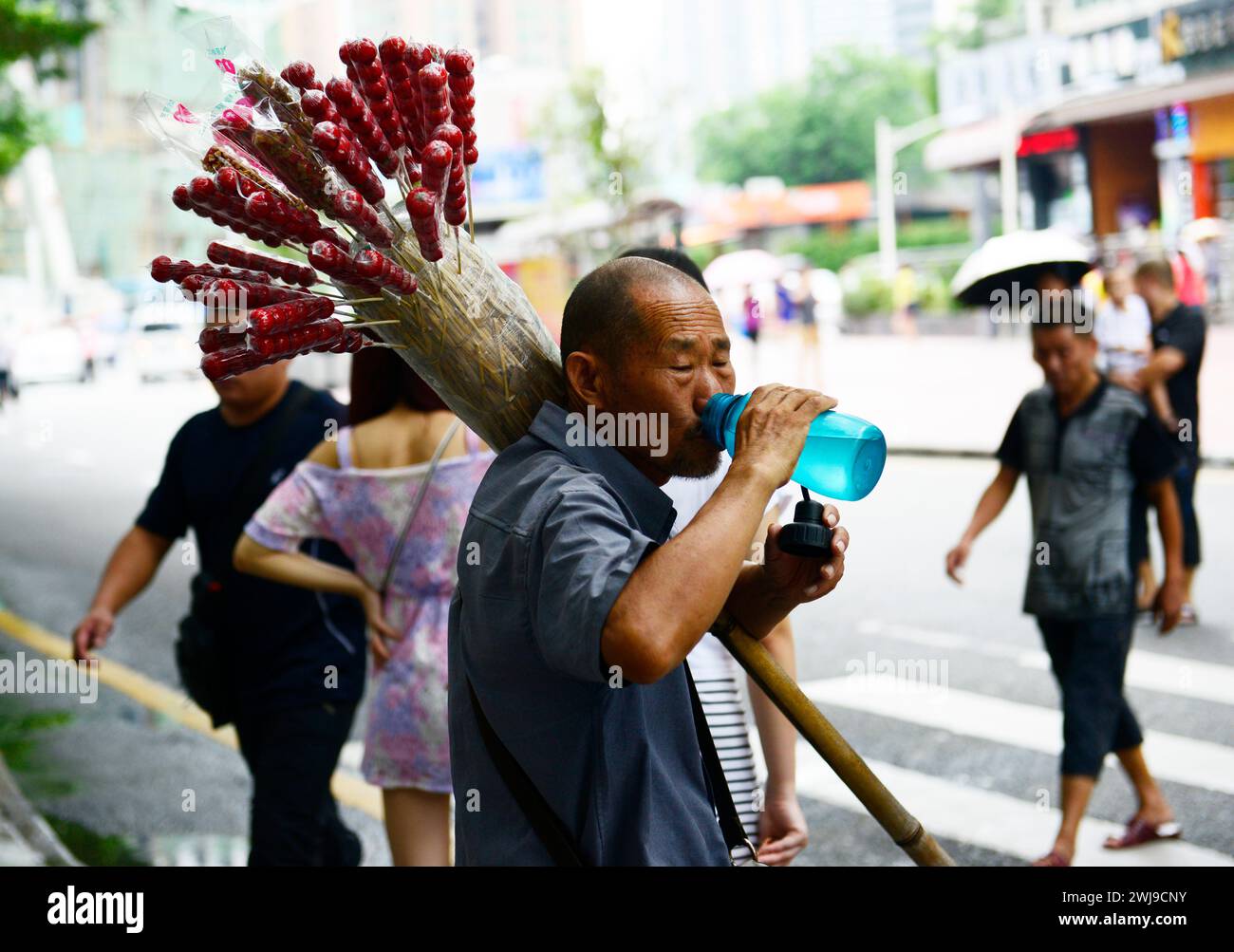 Un uomo anziano che vende caramelle a Shenzhen, in Cina. Foto Stock