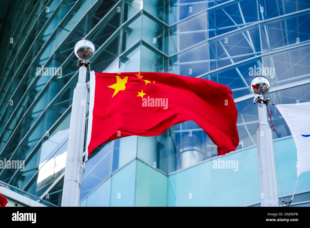 La bandiera cinese fluttua sullo sfondo degli edifici della città Foto Stock