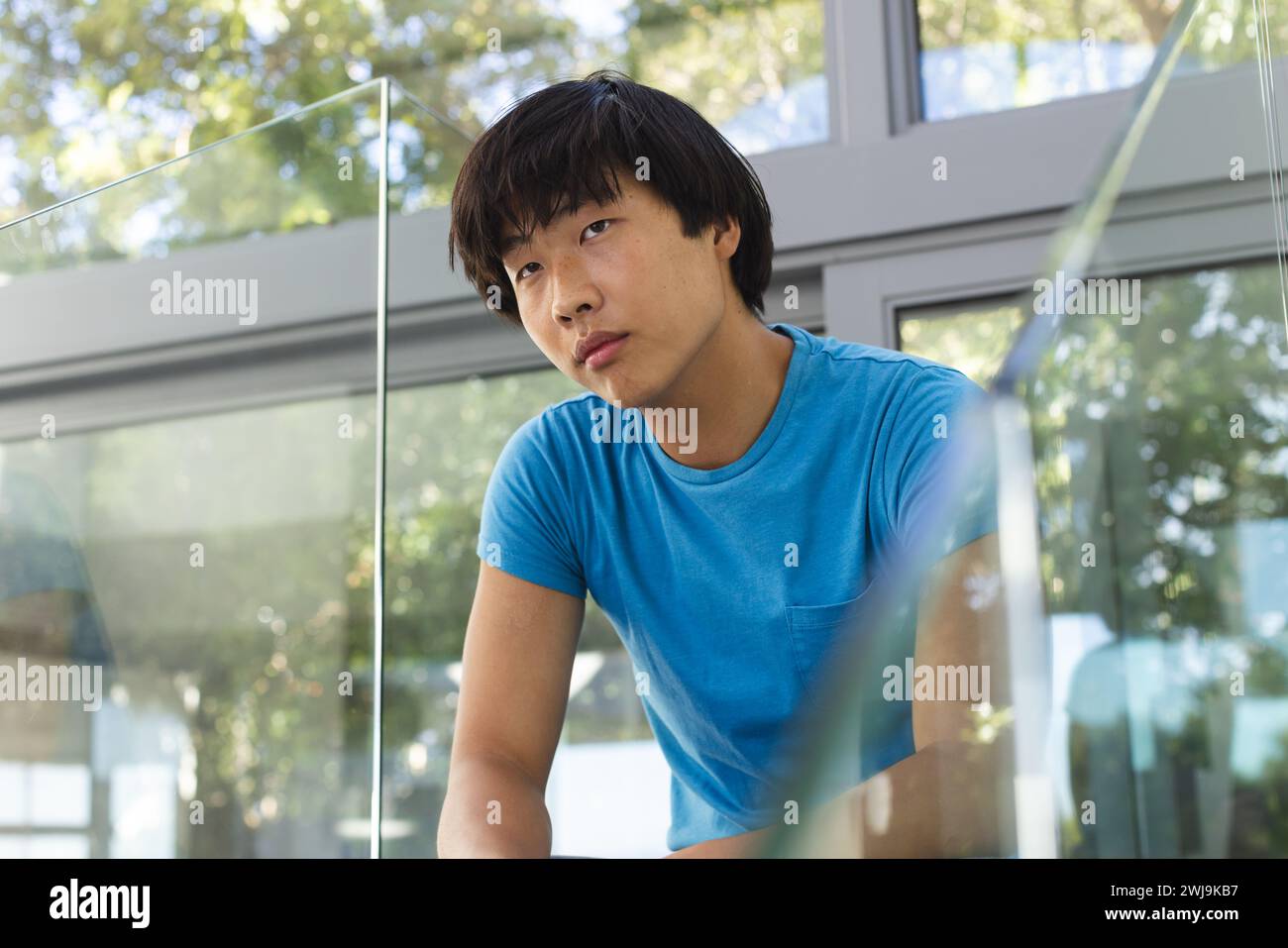 Adolescente ragazzo asiatico sembra contemplativo a scuola Foto Stock