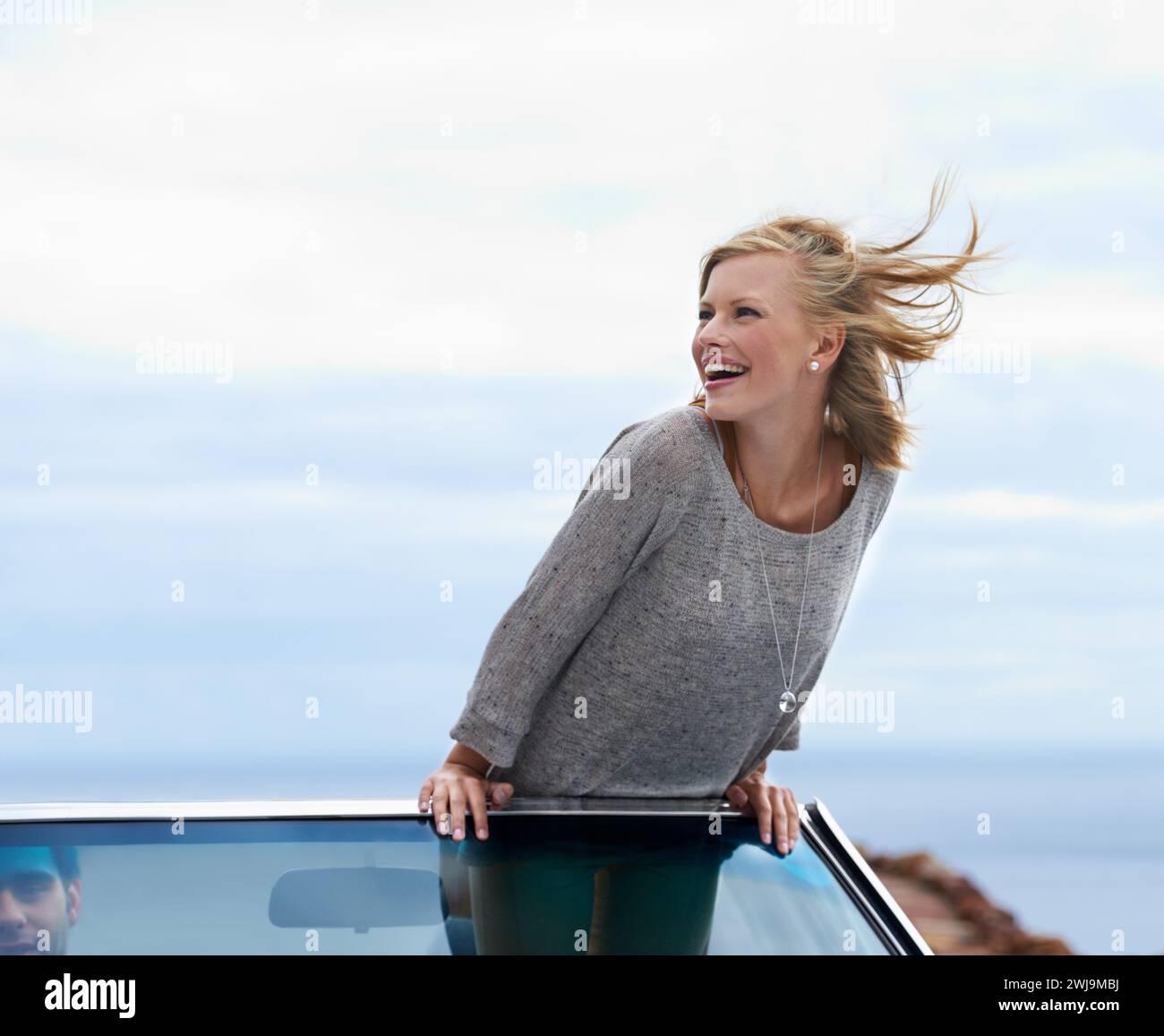 Felice cielo blu e auto convertibile con donna in viaggio per viaggi, vacanze o vacanze in estate. Spazio, sorriso e viaggio con i giovani Foto Stock