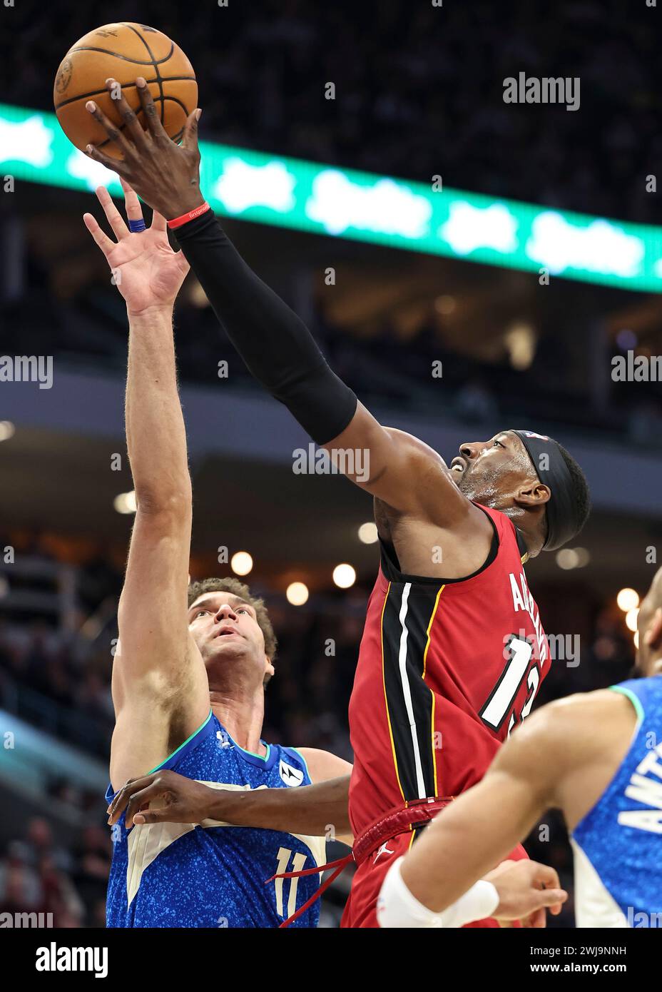 Milwaukee, Stati Uniti. 13 febbraio 2024. Il centro di Miami Heat Bam Adebayo (R) guida al basket contro il centro dei Milwaukee Bucks Brook Lopez durante la partita di stagione regolare NBA 2023-2024 tra i Miami Heat e i Milwaukee Bucks al Fiserv Forum di Milwaukee, negli Stati Uniti, il 13 febbraio 2024. Crediti: Joel Lerner/Xinhua/Alamy Live News Foto Stock