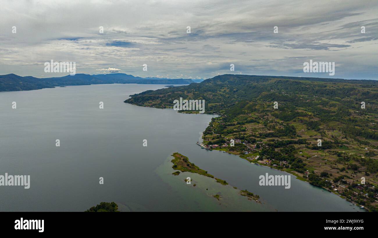 Vista dall'alto del bellissimo lago Toba e di un'isola con palme. Samosir, Pulau Toba. Sumatra, Indonesia. Foto Stock