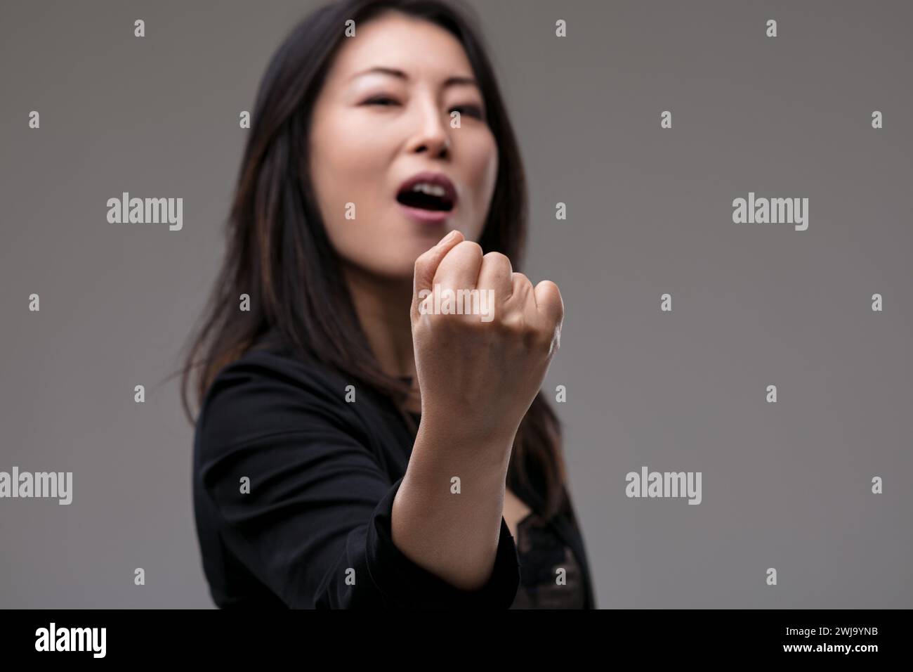 Trasuda forza, il suo pugno alzato e la sua espressione enfatica parlano di un momento di trionfo Foto Stock