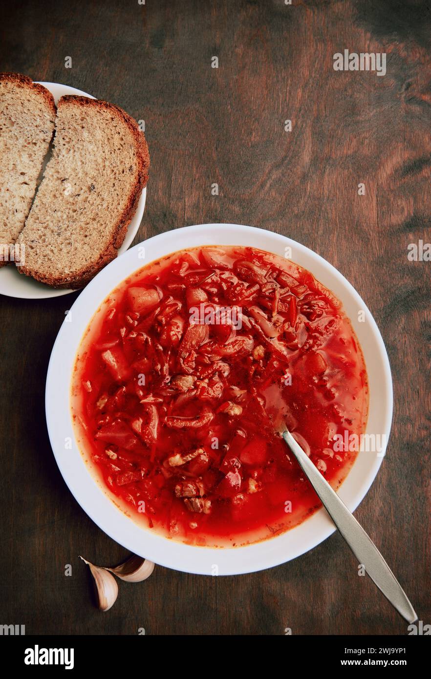 Borsch in piatto su tavolo di legno grezzo, una tradizionale zuppa russa e Ucraina. Borscht, un piatto di cucina slava. Vista dall'alto Foto Stock