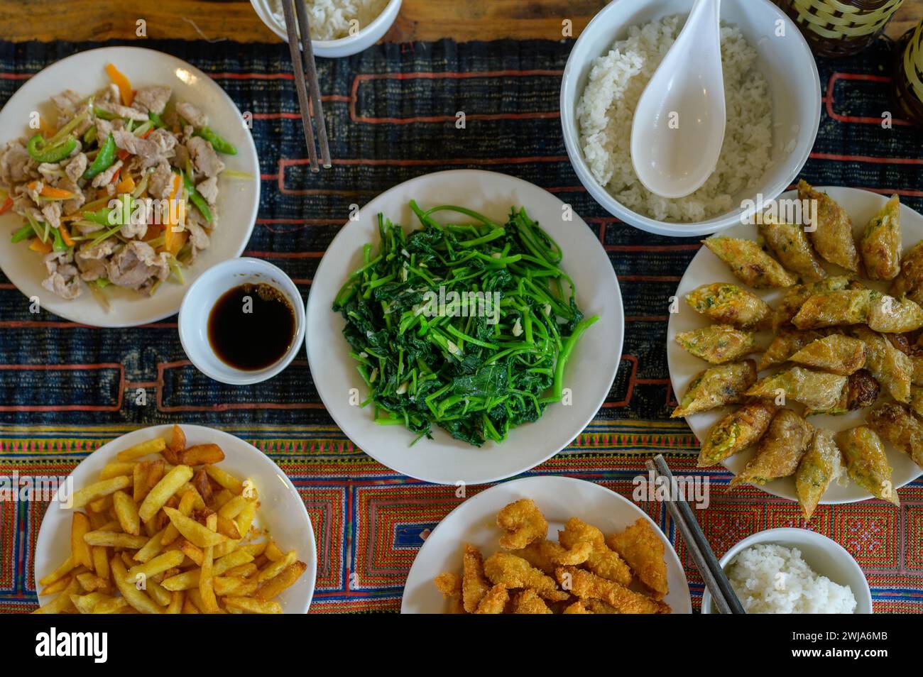 Dall'alto della deliziosa insalata di zuppa di patate fritte involtini primavera di riso serviti su tovaglie a scacchi nel ristorante Foto Stock