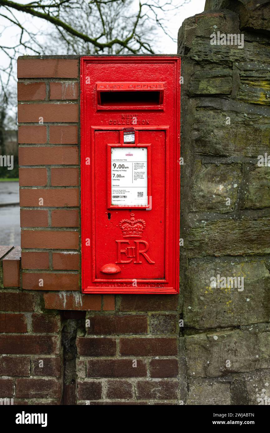 Kearsley Manchester gennaio 2024, Royal mail Square casella posta rossa nella parete in pietra e mattoni con tempi di raccolta stampati su targhetta bianca UK Foto Stock