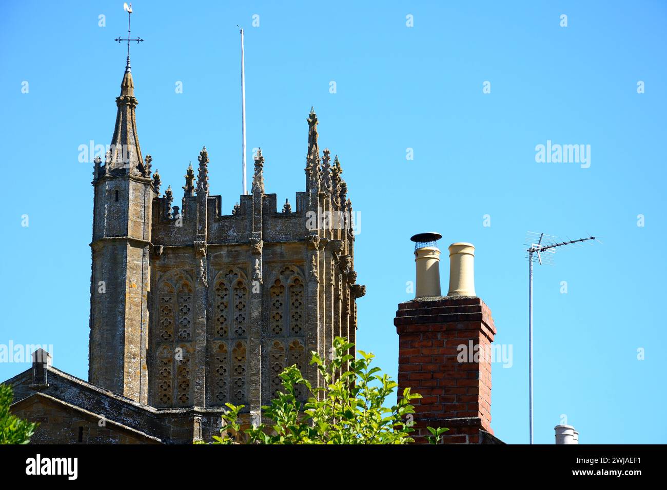 Vista della torre della cattedrale e di un tradizionale camino in mattoni, Ilminster, Somerset, Regno Unito, Europa Foto Stock