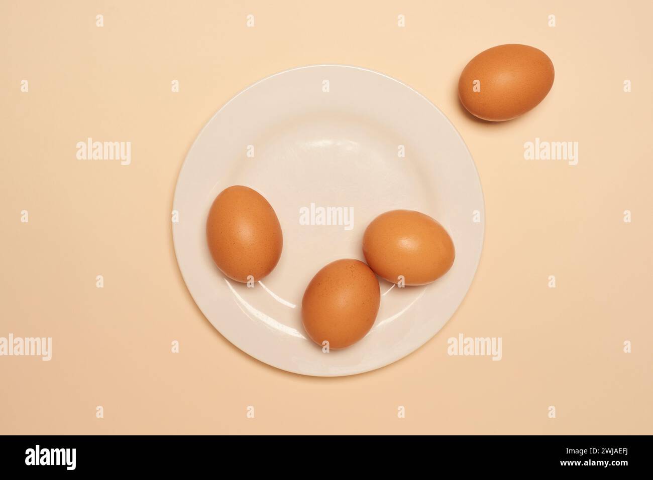 Uova su un piatto bianco, dall'alto, su uno sfondo colorato Foto Stock