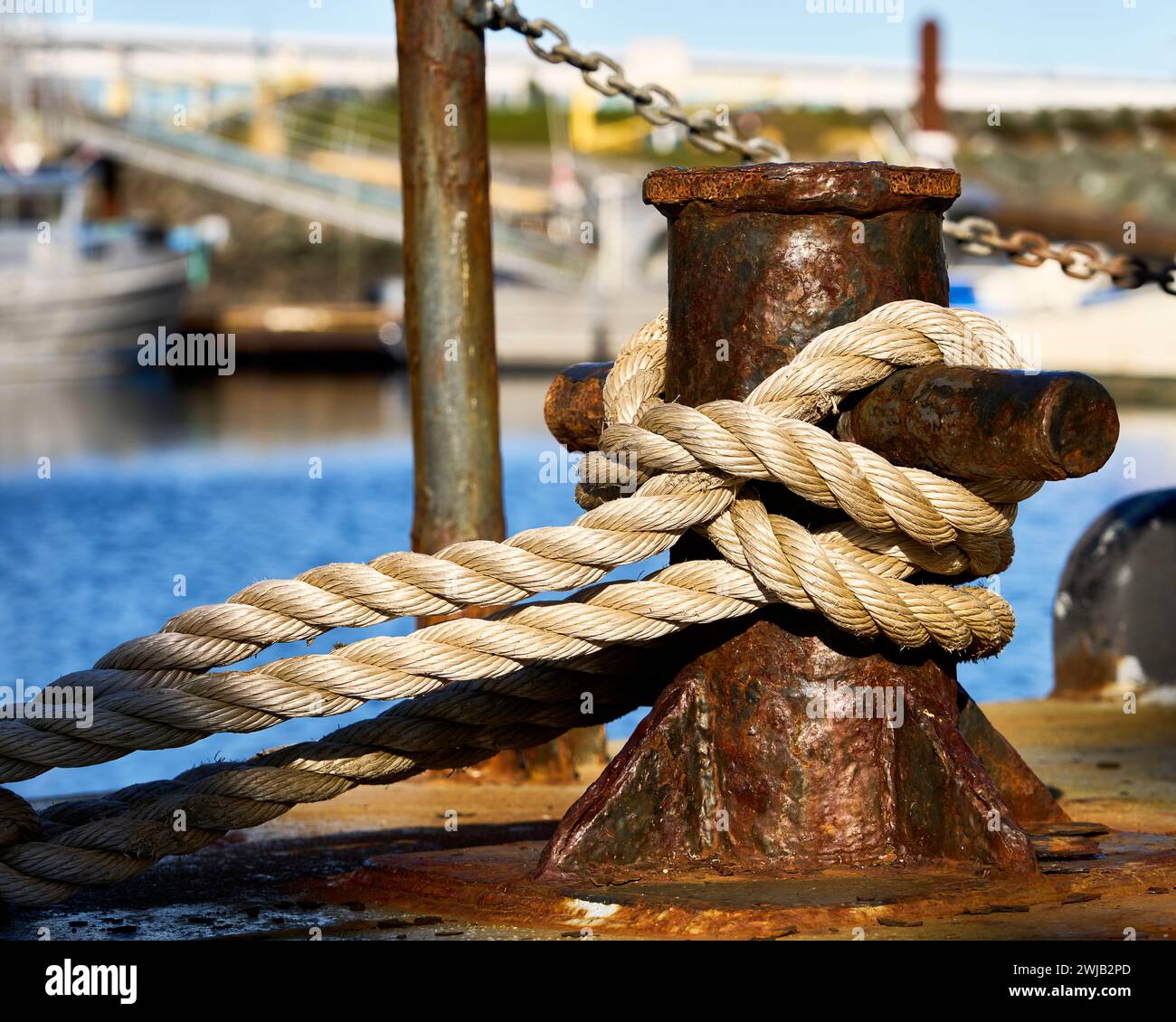 Un primo piano di una fila di barche che è avvolta intorno a una vecchia scarpa arrugginita in un porticciolo sull'oceano. Foto Stock