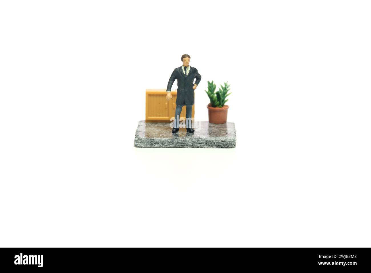 Fotografia di figure giocattolo in miniatura. Concetto di progettazione del layout della postazione di lavoro. Un uomo d'affari, ceo che controlla il personale. Isolato su un whi Foto Stock