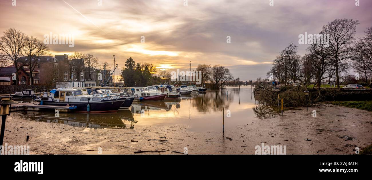 Porto ricreativo Gelrehaven durante l'alto livello dell'acqua del fiume IJssel con banchina in primo piano al colorato tramonto Foto Stock