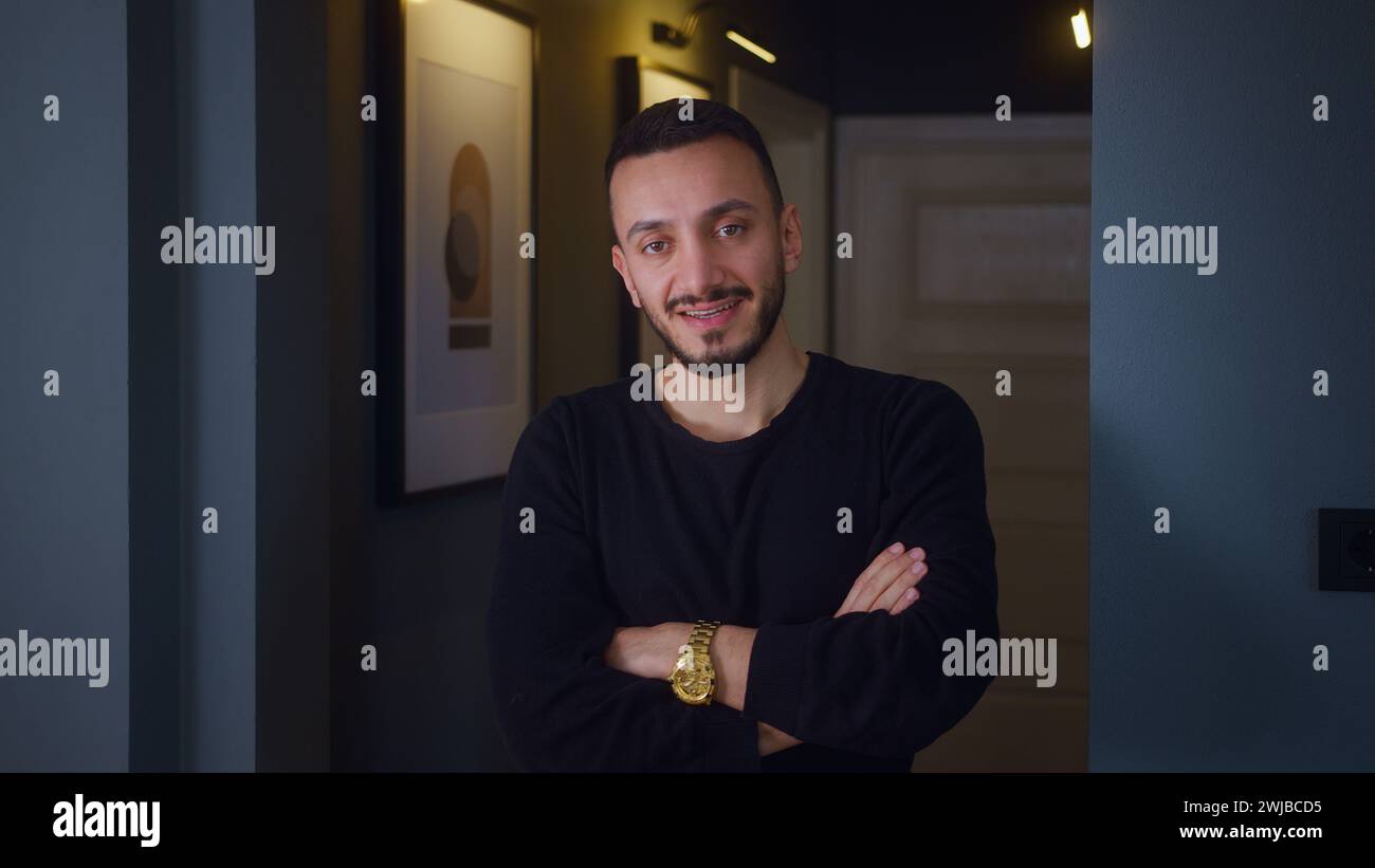 Vlogger uomo in piedi davanti all'ingresso della hall di casa che guarda la webcam che parla con la fotocamera, videoconferenza in chat virtuale con i social Foto Stock