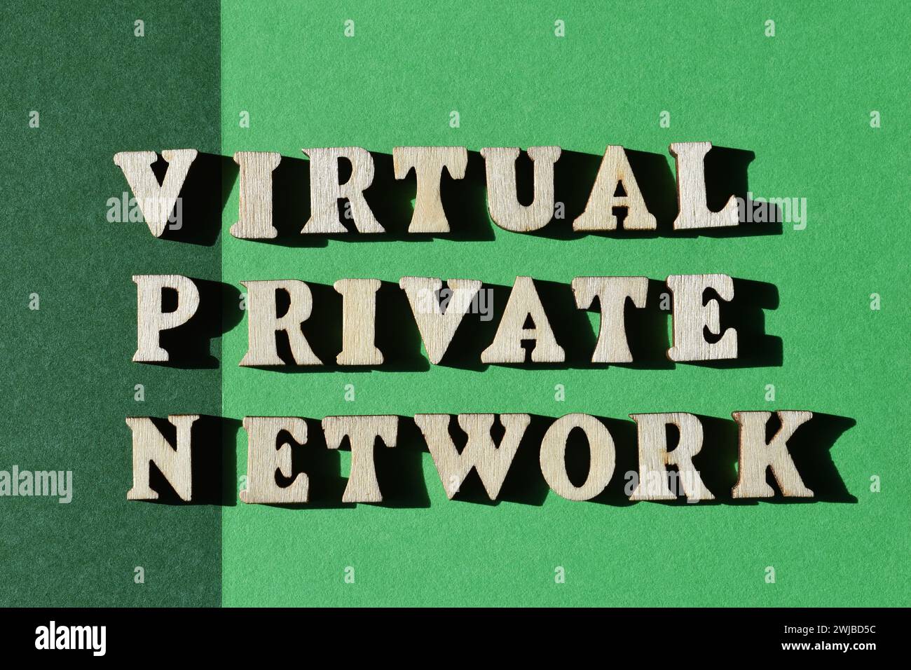 VPN, acronimo di Virtual Private Network, parole in caratteri alfabetici in legno isolate su sfondo verde Foto Stock