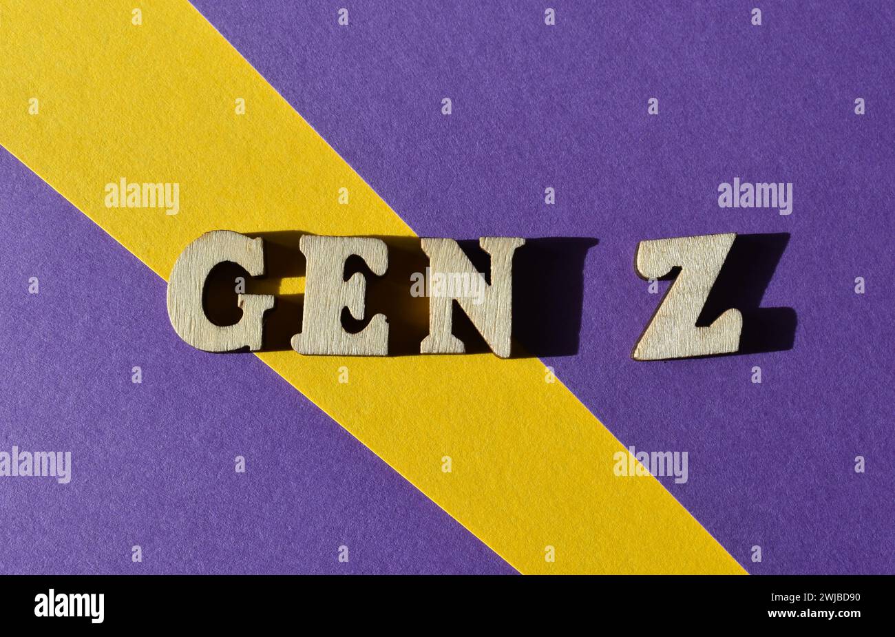 Gen Z, abbreviazione di generazione Z, parole in alfabeto di legno isolate su sfondo viola e giallo come titolo del banner Foto Stock