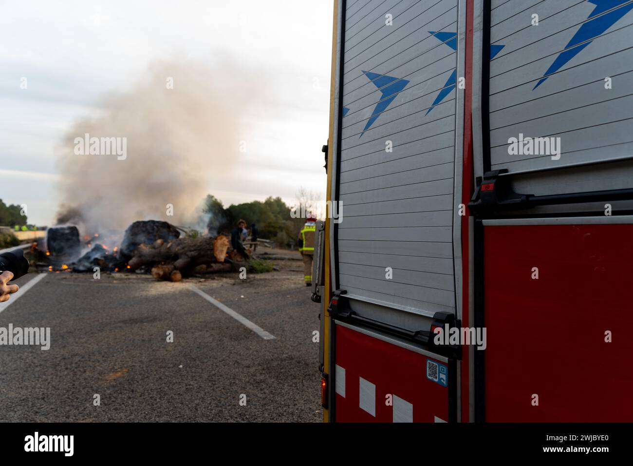 14 febbraio 2024 Pontos, Girona, Spainpol Pontos, Girona, Catalogna, Spagna - gli agricoltori stanno mettendo fine al blocco stradale. Ultime notizie: Il blocco al confine tra Spagna e Francia attuato dagli agricoltori catalani sta per finire. Hanno raggiunto un incontro con il governo spagnolo e le autorità catalane, anche se alcuni agricoltori sono rimasti sconvolti perché volevano rimanere fino al raggiungimento di un accordo definitivo. Nonostante gli agricoltori comincino a partire, la strada rimarrà chiusa a causa dei numerosi falò che hanno danneggiato l'asfalto. Noticia de &#xfa;ltima hora, se está acabando el bloque Foto Stock