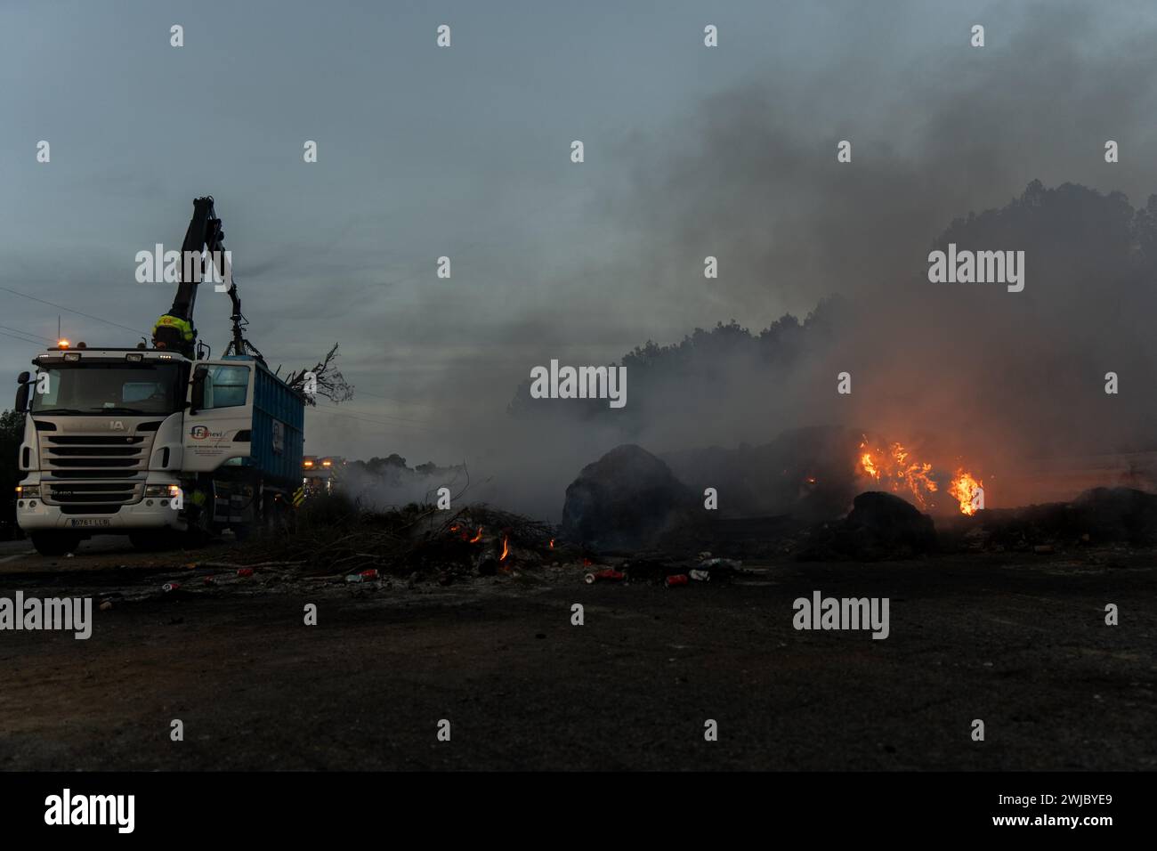 14 febbraio 2024 Pontos, Girona, Spainpol Pontos, Girona, Catalogna, Spagna - gli agricoltori stanno mettendo fine al blocco stradale. Ultime notizie: Il blocco al confine tra Spagna e Francia attuato dagli agricoltori catalani sta per finire. Hanno raggiunto un incontro con il governo spagnolo e le autorità catalane, anche se alcuni agricoltori sono rimasti sconvolti perché volevano rimanere fino al raggiungimento di un accordo definitivo. Nonostante gli agricoltori comincino a partire, la strada rimarrà chiusa a causa dei numerosi falò che hanno danneggiato l'asfalto. Noticia de &#xfa;ltima hora, se está acabando el bloque Foto Stock