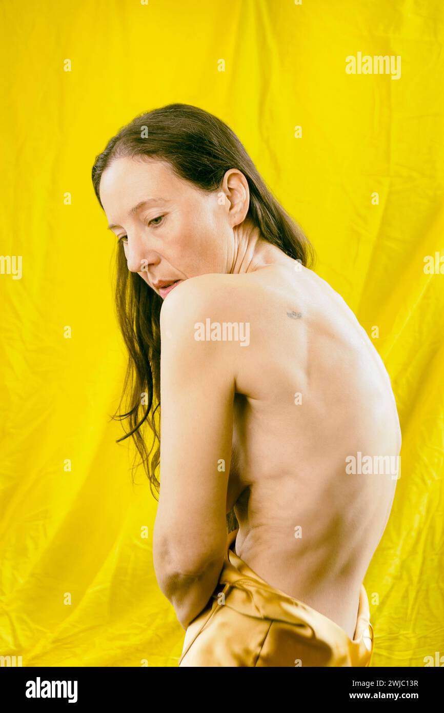 donna in raso giallo che mostra la schiena in un atteggiamento romantico, spagna Foto Stock