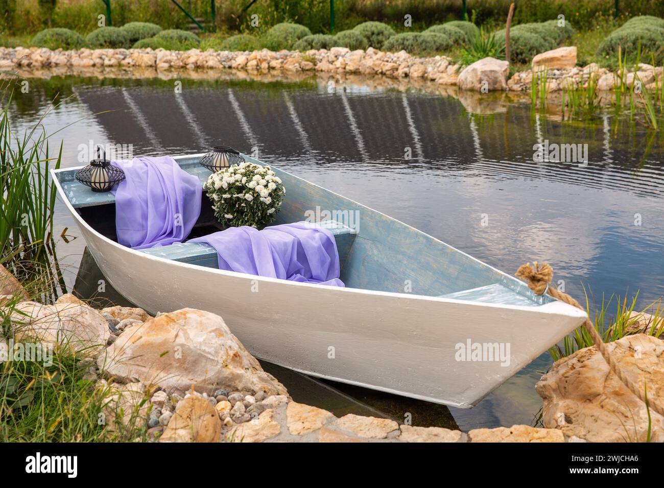 Paesaggio rurale con laghetto, barca in legno e campo di lavanda. Foto Stock