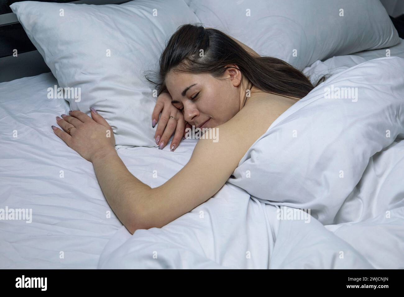 La ragazza dorme in un letto bianco. Foto Stock