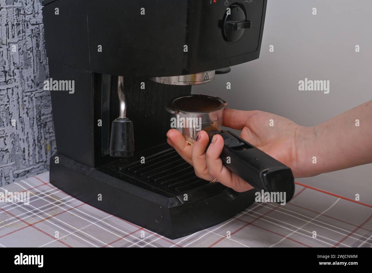 Le mani di una donna preparano il caffè con una macchina per il caffè di casa Foto Stock