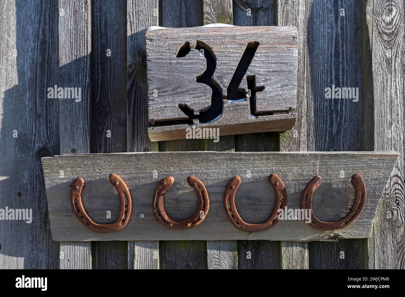Horseshoe sotto un numero civico su un fienile, Baviera, Germania Foto Stock