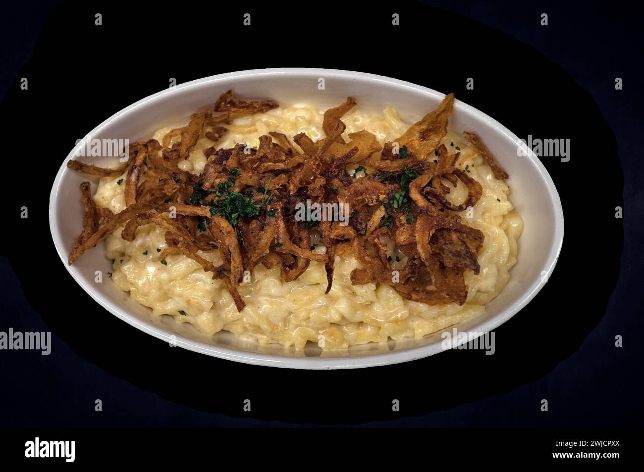 Spaetzle di formaggio con cipolle fritte su sfondo scuro, Baviera, Germania Foto Stock