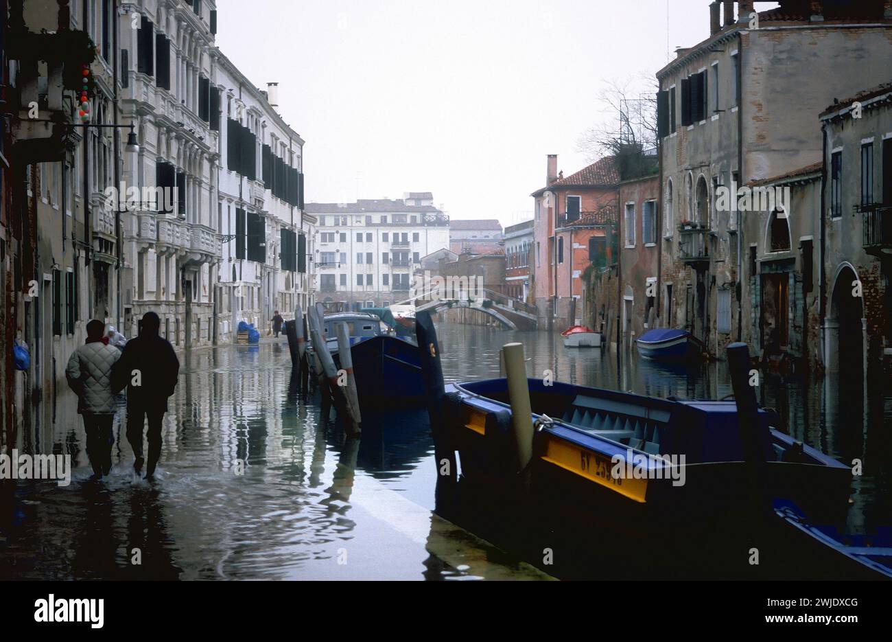 Persone che camminano attraverso le acque alluvionali, Aqua alta, Venezia, Italia Foto Stock