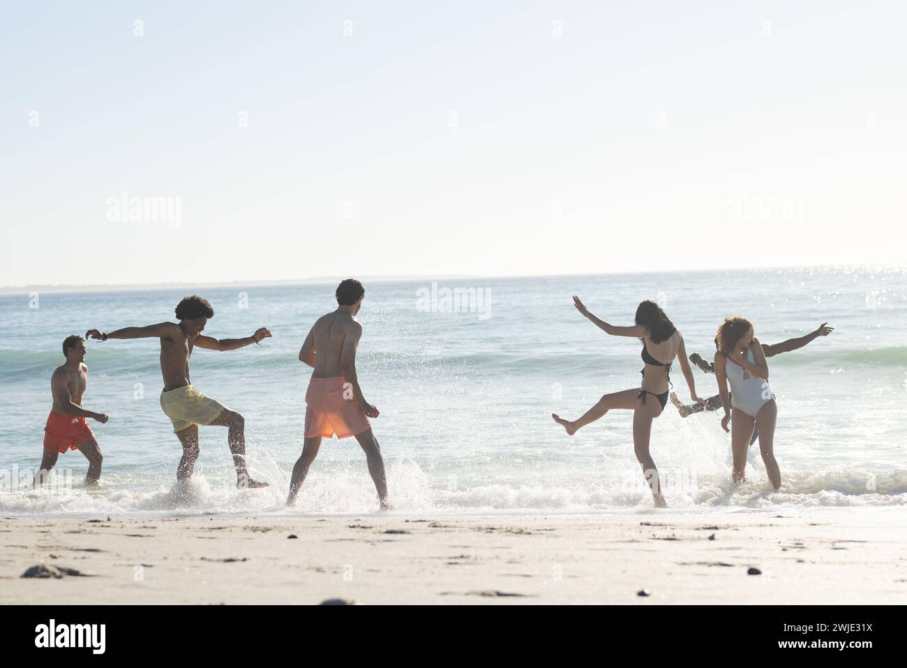 Gruppi diversi di amici trascorrono una giornata in spiaggia, con spazio per le copie Foto Stock