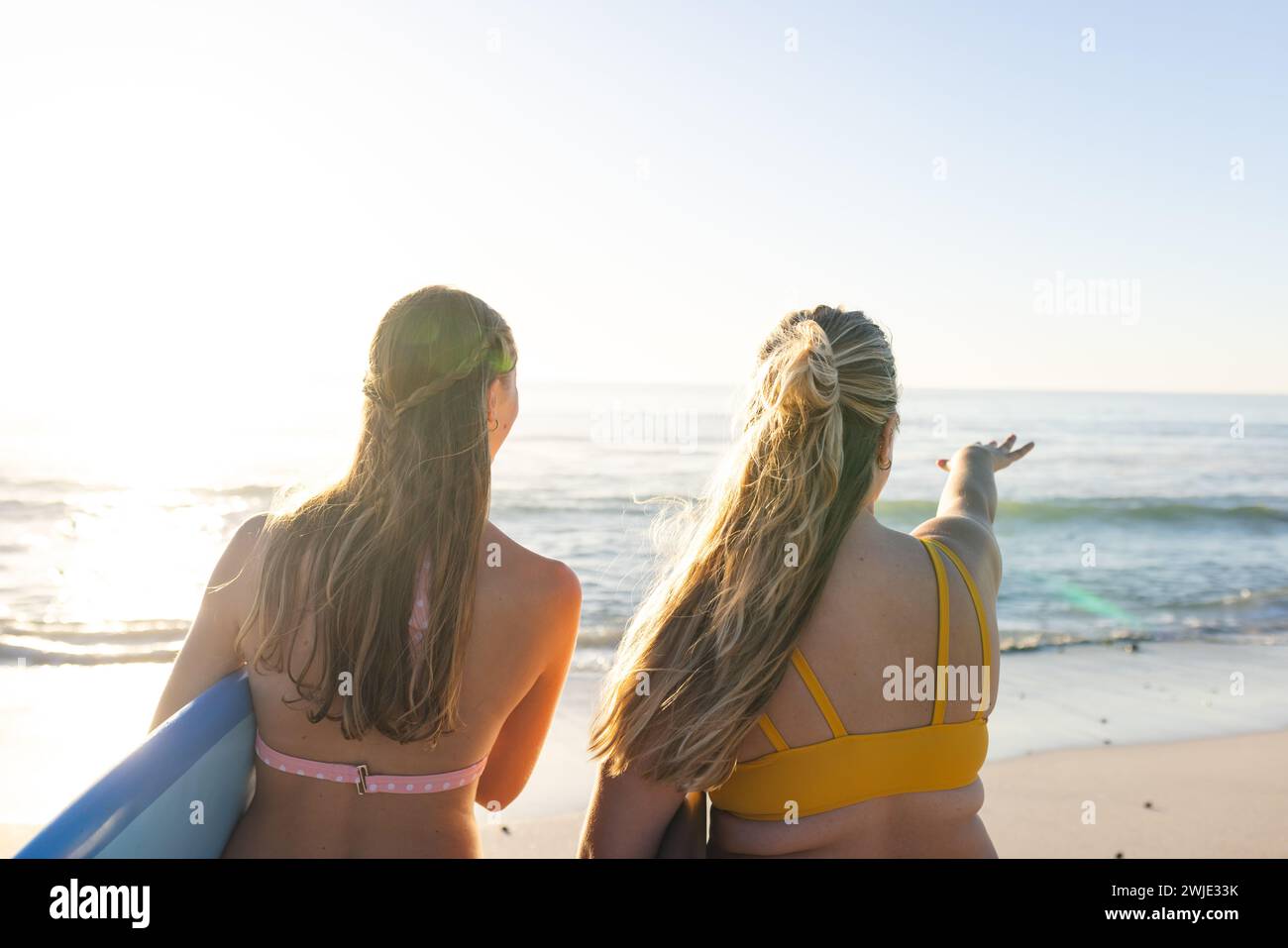 Due giovani donne caucasiche guardano l'oceano, con spazio di copia Foto Stock