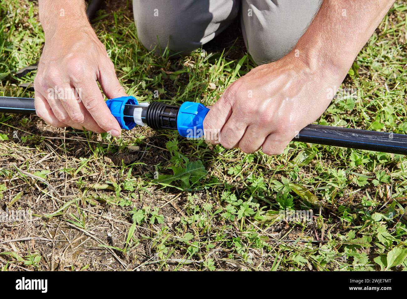 Assemblaggio di tubazioni per l'acqua potabile e l'irrigazione del giardino, parti del sistema di alimentazione dell'acqua sono collegate con un raccordo di accoppiamento a compressione. Foto Stock