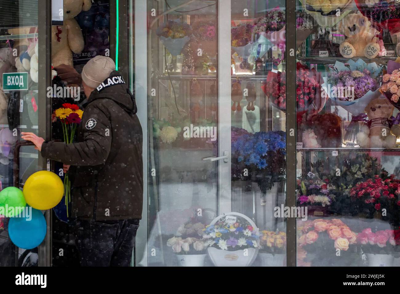 St Pietroburgo, Russia. 14 febbraio 2024. Un uomo entra in un negozio di fiori durante le celebrazioni di San Valentino il 14 febbraio a San Pietroburgo. (Foto di Artem Priakhin/SOPA Images/Sipa USA) credito: SIPA USA/Alamy Live News Foto Stock