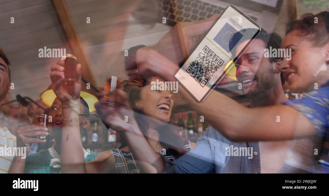 Uomo con in mano uno smartphone con codice qr sullo schermo contro un gruppo di amici che bevono foto insieme Foto Stock