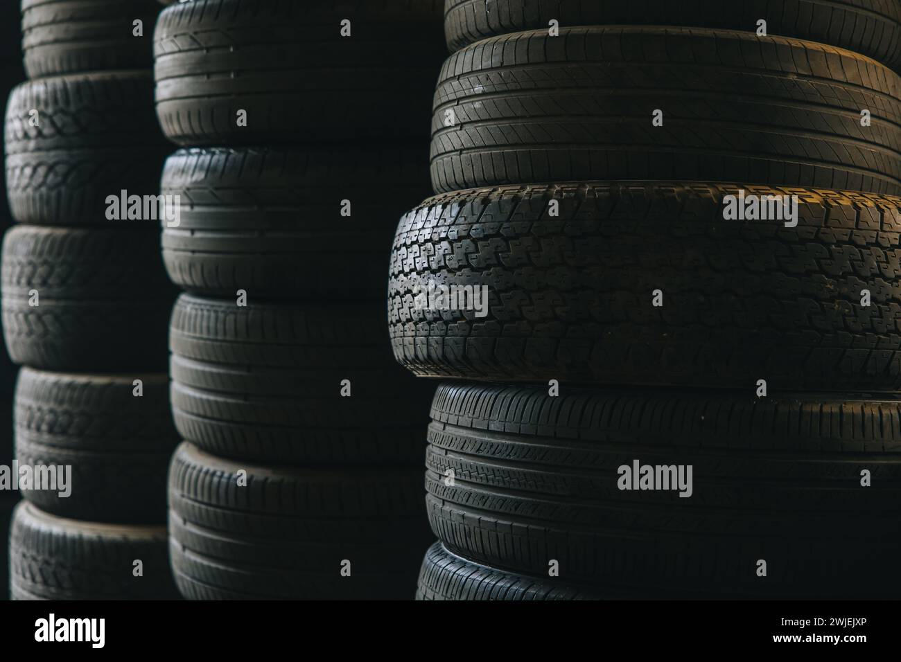 vecchi pneumatici per auto usate rifiuti di gomma impilati necessità di riciclare rifiuti di impatto ambientale Foto Stock
