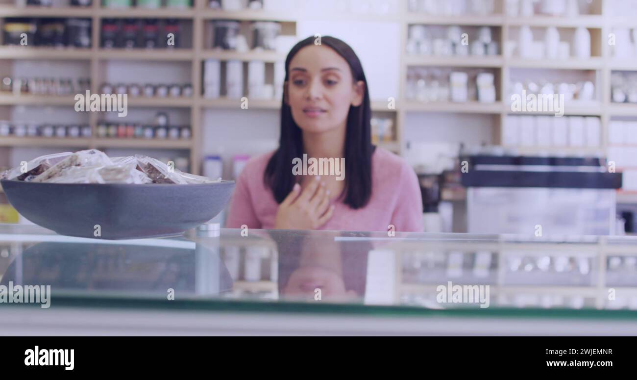 Una giovane donna birazziale sta dietro un bancone in un negozio Foto Stock