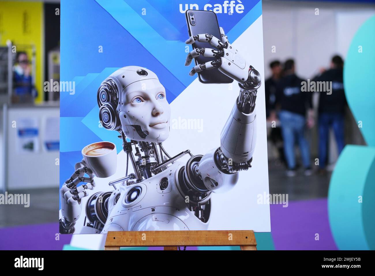 Torino, Italia - 14 febbraio 2024: L'immagine di un robot che scatta un selfie con una tazza di caffè accoglie i visitatori all'ingresso della fiera annuale della tecnologia Foto Stock