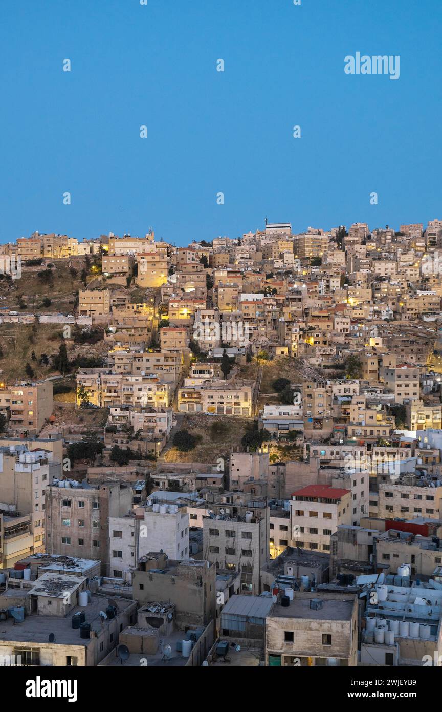 Il vivace paesaggio urbano di Amman vanta un contrasto sorprendente di edifici torreggianti contro un pittoresco sfondo di montagne, che mostrano la bellezza dell'urba Foto Stock