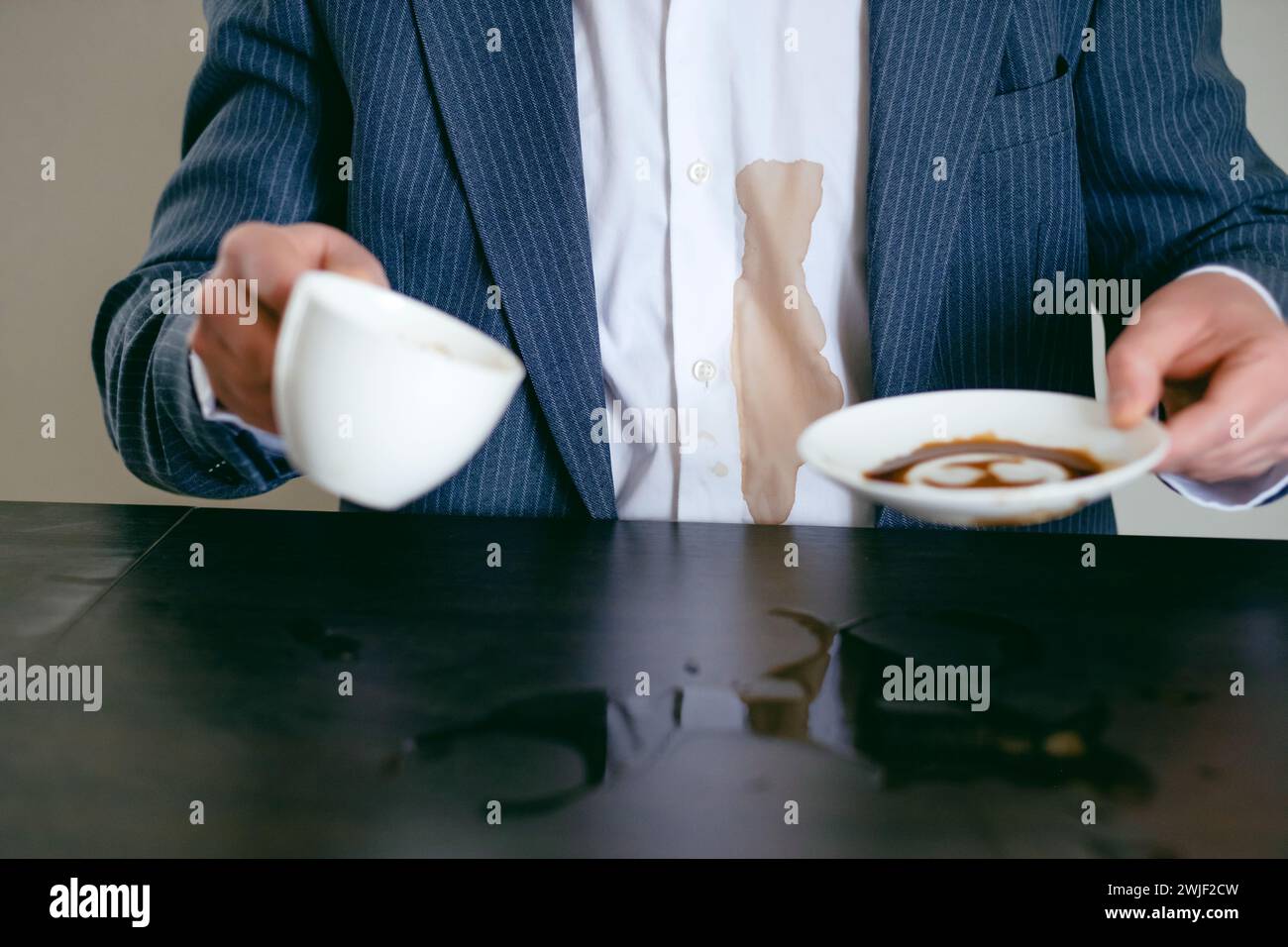 Irriconoscibile un uomo con un vestito ha versato caffè su una camicia bianca nel caffè. Macchie di caffè marrone sporche sui vestiti. concetto di colorazione della vita quotidiana. Foto Stock