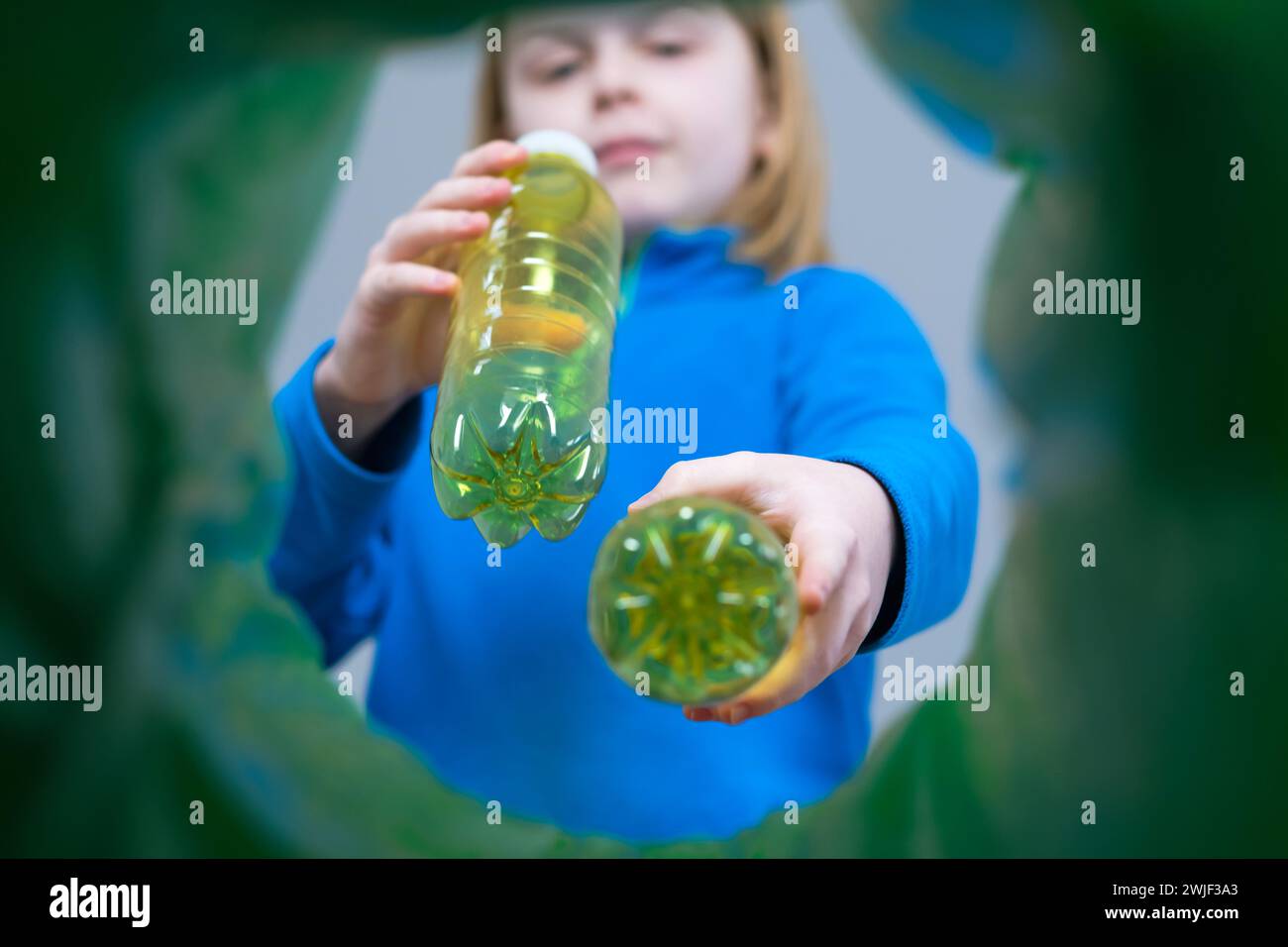 Contenitore di riciclaggio POV per biberon in plastica gialle con vista ad angolo basso. Sostenibile e rispettoso dell'ambiente Foto Stock