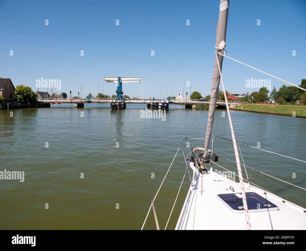 Barca a vela in avvicinamento al ponte in attesa di apertura - 1/4, Warnsebrug sul canale Johan Frisokanaal in Frisia, Paesi Bassi Foto Stock