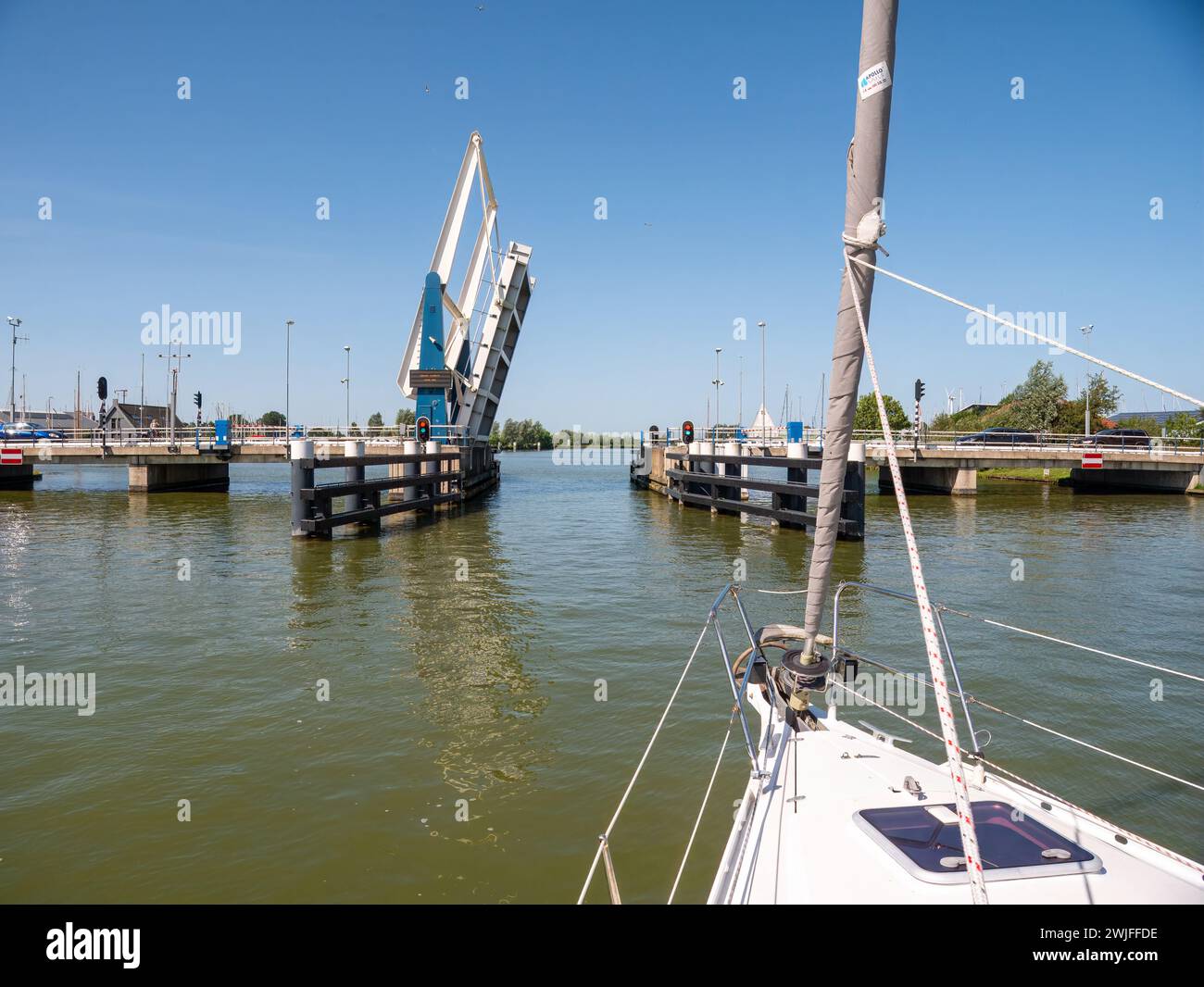 Barca a vela in avvicinamento al ponte in attesa di apertura - 3/4, ponte Warnsebrug sul canale Johan Frisokanaal in Frisia, Paesi Bassi Foto Stock