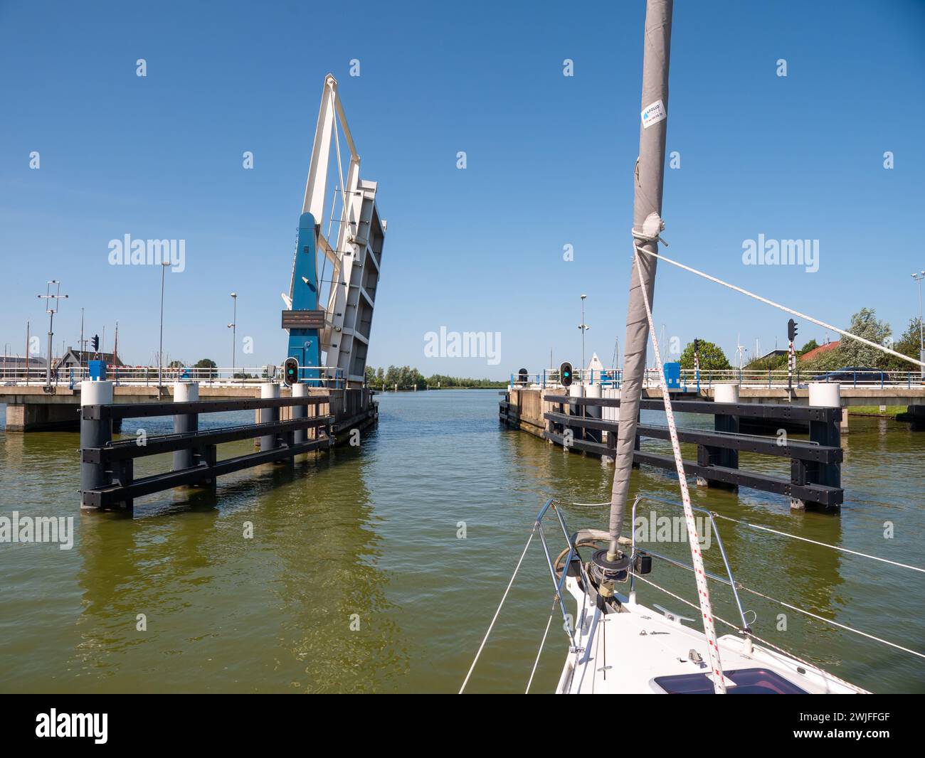 Barca a vela in avvicinamento al ponte in attesa di apertura - 4/4, ponte Warnsebrug sul canale Johan Frisokanaal nella Frisia, Paesi Bassi Foto Stock