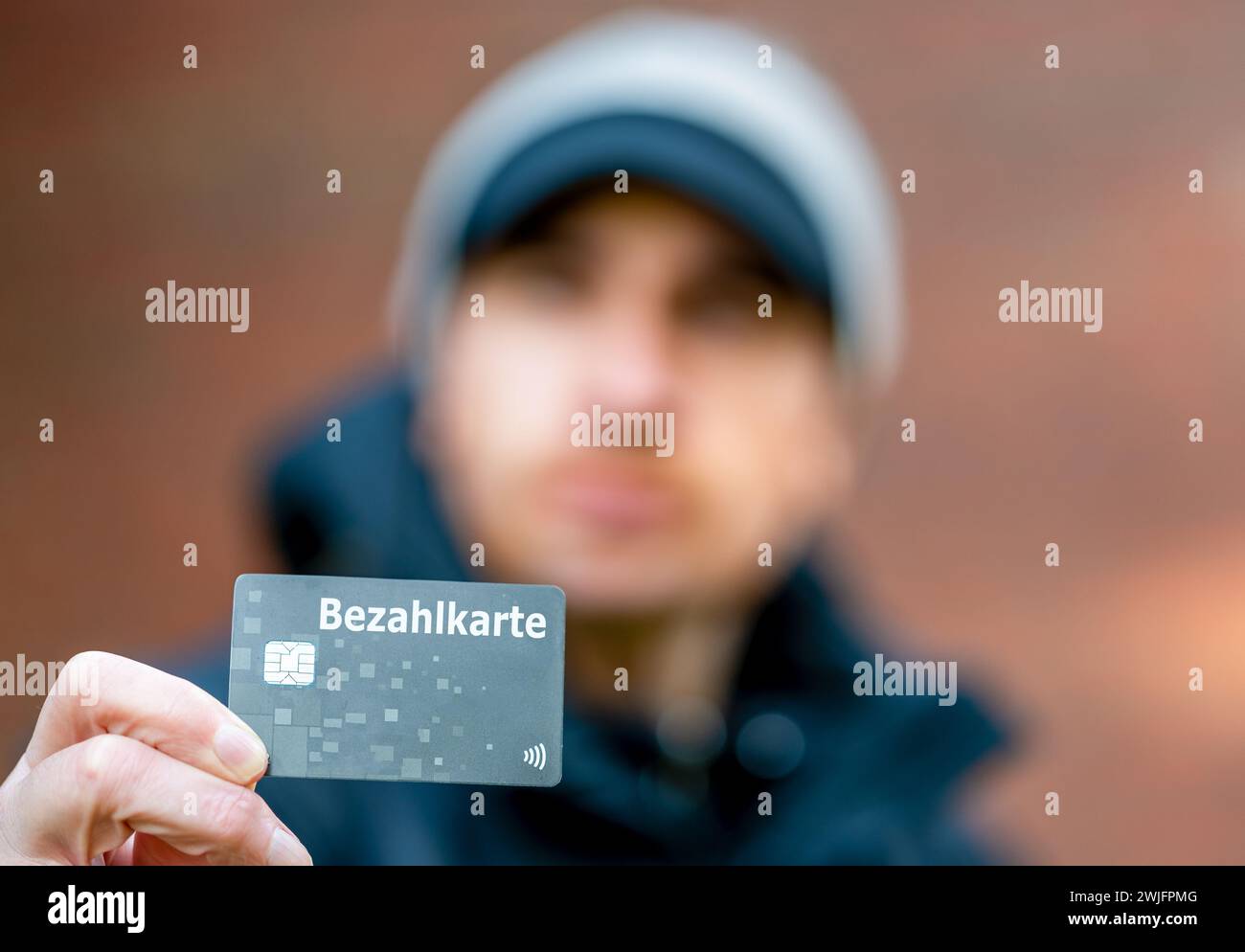 Un rifugiato con una carta di pagamento (Bezahlkarte) in Germania. Simbolo della nuova carta di pagamento per i rifugiati in Germania. Foto Stock