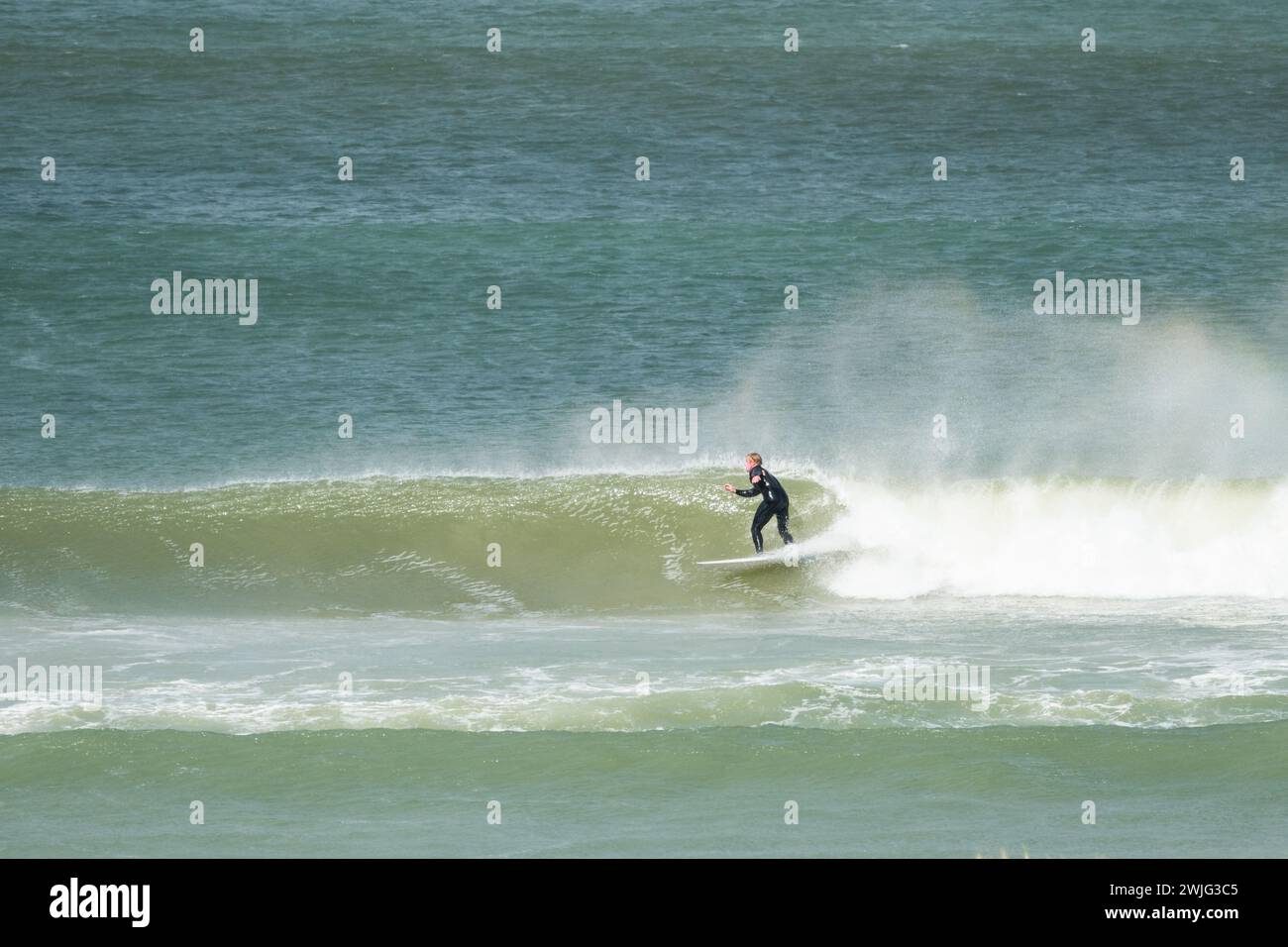 Surfista su una tavola da surf, fai surf sulle onde o rompi a Bettys Bay, Capo Occidentale, Sud Africa Foto Stock