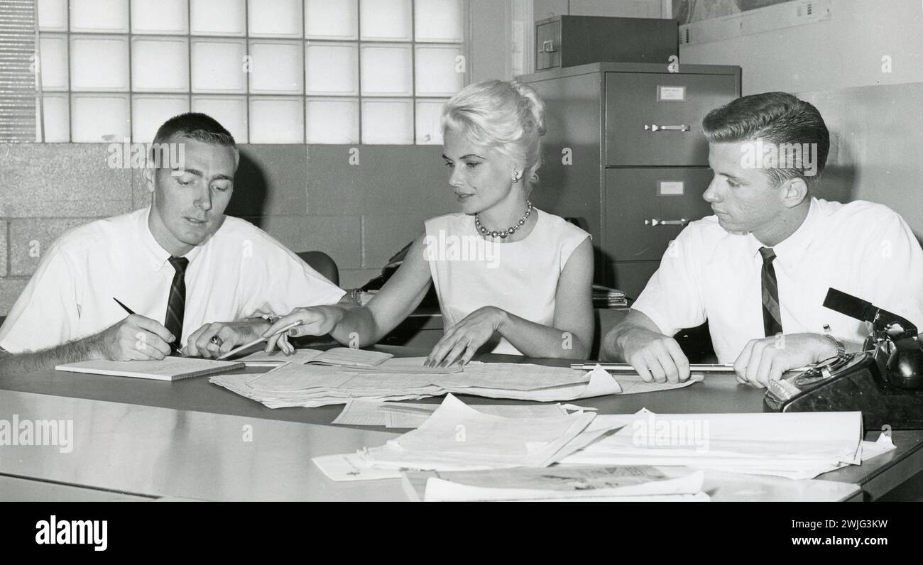 Analizzando un complesso problema matematico, la signora Helen Mann dirige il lavoro di due dei sei ingegneri maschi che supervisiona. Gran parte del lavoro dettagliato di questi ingegneri è alimentato da grandi computer elettronici che producono risposte rapide sui razzi di tracciamento, Cape Kennedy, Florida, 1962. (Foto di Chris Butler/NASA) Foto Stock