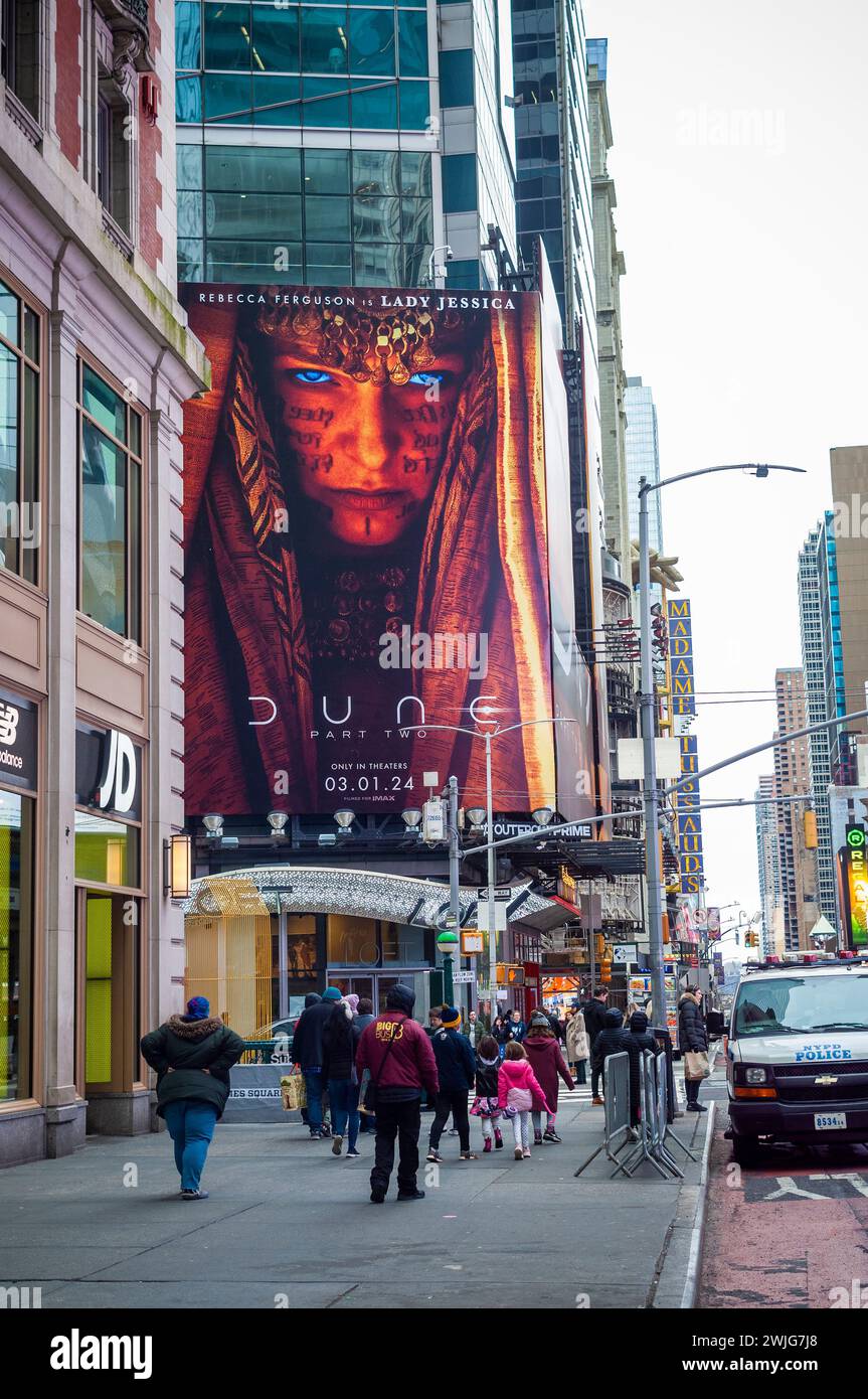 Orde di persone attraversano West 42nd Street sotto pubblicità per la Warner Bros. PicturesÕ ÒDune: Parte TwoÓ del film a Times Square a New York domenica 11 febbraio 2024. Il film dovrebbe essere distribuito il 1° marzo. (© Richard B. Levine) Foto Stock