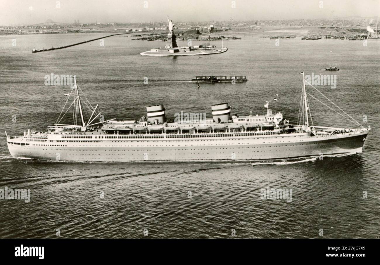 SS Nieuw Amsterdam nel porto di New York, passando davanti alla Statua della libertà Foto Stock