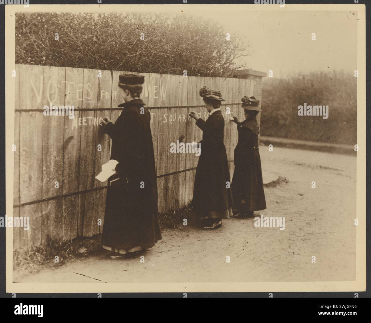 Immagine storica delle Suffragette di donne che scrivono su una recinzione di legno 'Vota per le donne' con il luogo del prossimo incontro. Dai documenti di Bessie Rischbiet, leader australiano del movimento. Foto Stock
