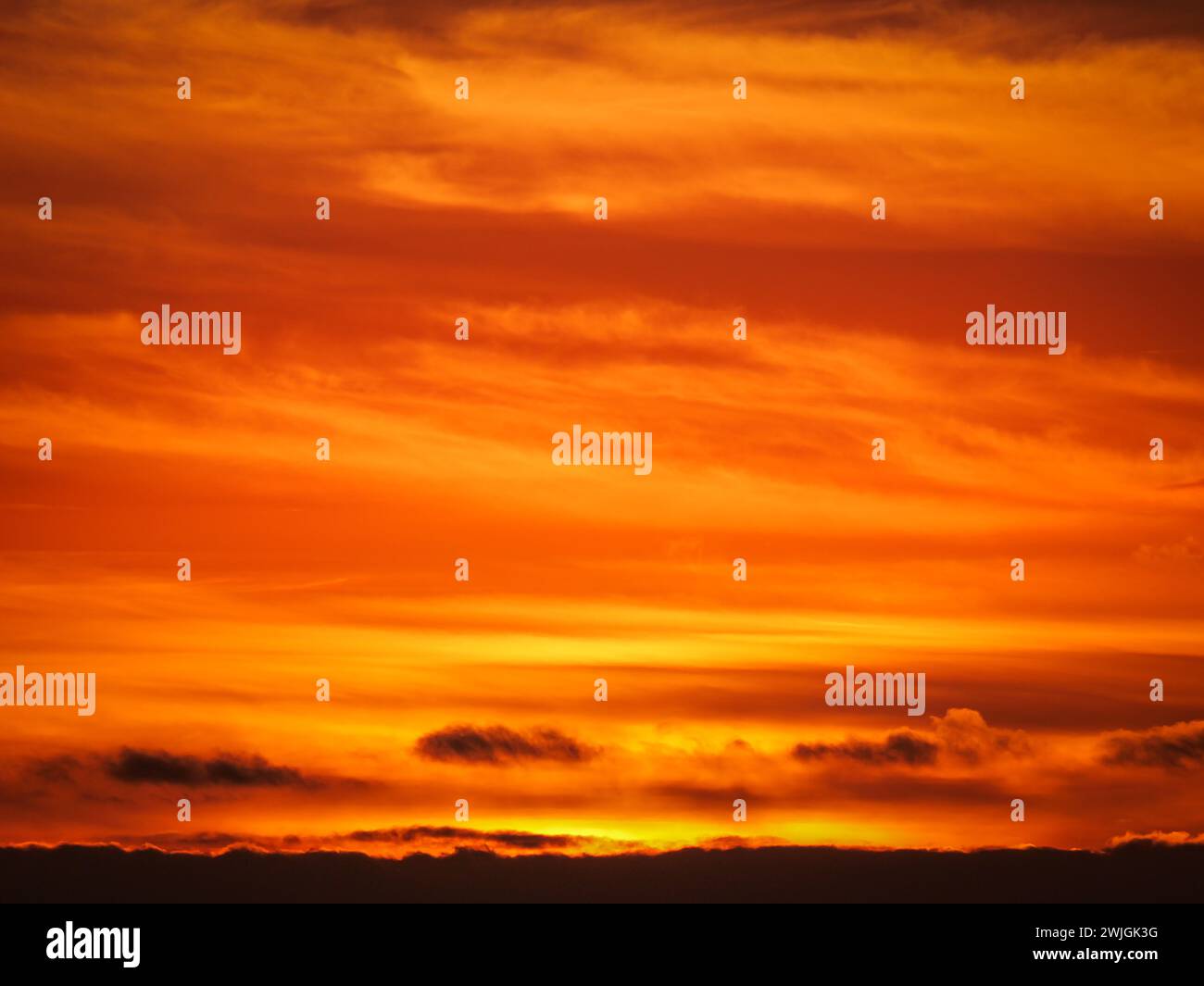 arancione giallo fuoco cielo con nuvole Foto Stock