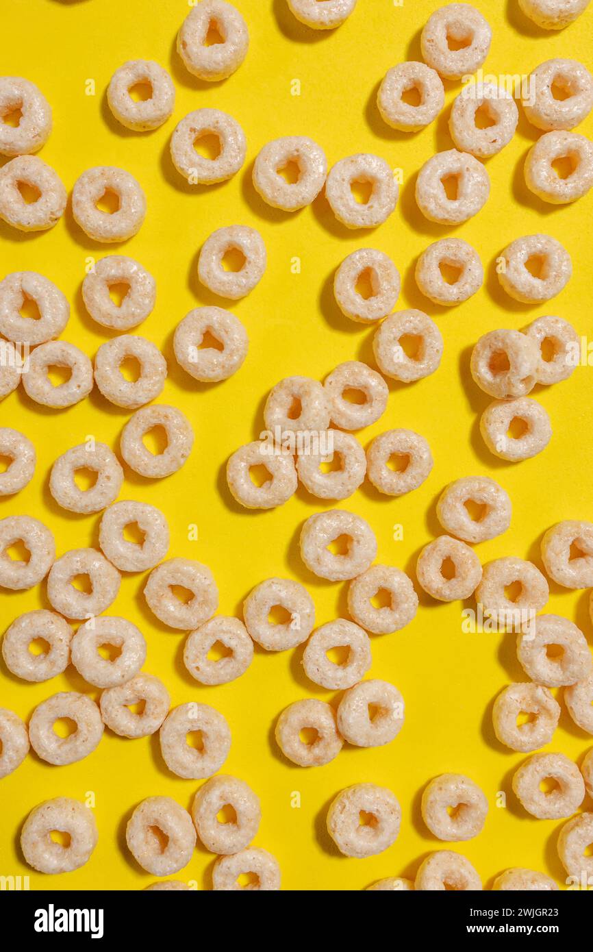 Cereali a forma circolare su sfondo giallo brillante, vista dall'alto Foto Stock