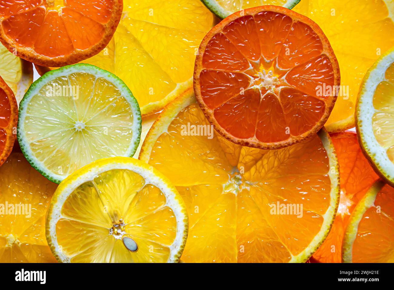 Vari agrumi a fette come sfondo. Frutta fresca e matura, vista dall'alto. Foto Stock
